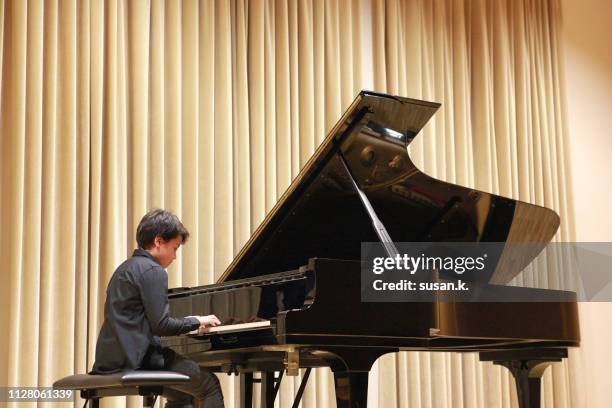 boy playing piano at the concert. - pianist stock-fotos und bilder