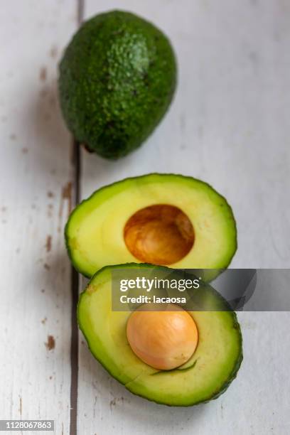 whole and sliced avocado - vegetarisches gericht photos et images de collection