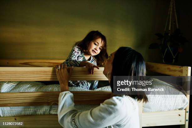young girl in discussion with mother while sitting on top bunk in bedroom - bunk beds for 3 stock pictures, royalty-free photos & images