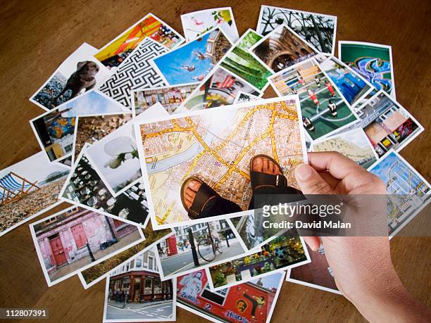 picture being lifted from pile of holiday snaps - human hand photos stock pictures, royalty-free photos & images