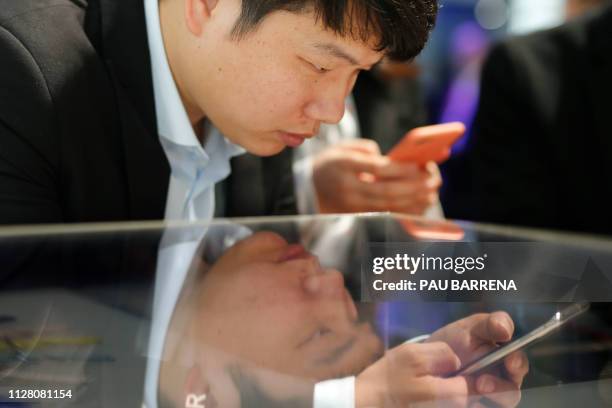 Visitor checks a Samsung Galaxy S10, at the Mobile World Congress in Barcelona on February 28, 2019. - Phone makers will focus on foldable screens...