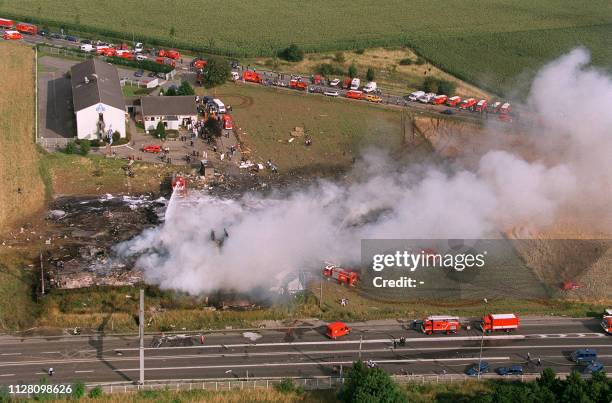 Debris smoulders at the site of the crash of an Air France Concorde 25 July 2000 at Gonesse near the Paris Charles de Gaulle airport. An engine of...
