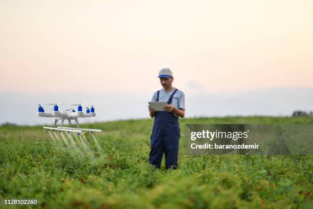 farmer spraying his crops using a drone - farmer drone stock pictures, royalty-free photos & images