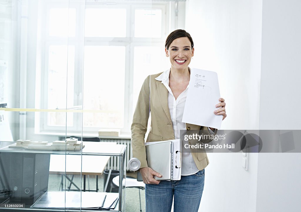 Young business woman holding contract, smiling