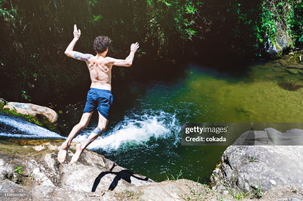 Young man jumping from a waterfall at Lumiar/RJ