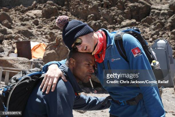 Osi Umenyiora and Dan Walker hug during day six of of 'Kilimanjaro: The Return' for Red Nose Day on February 28, 2019 in Arusha, Tanzania, all to...