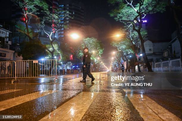 Vietnamese policemen stand guard outside the Melia hotel, where North Korean foreign minister holds a press conference, early on March 1 following...