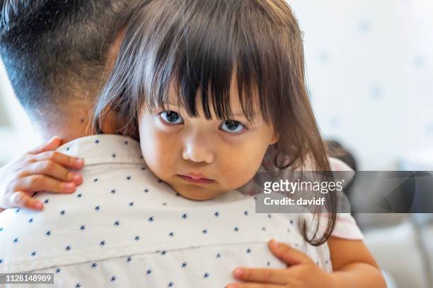 sad and crying daughter being comforted by her father - distraught family stock pictures, royalty-free photos & images