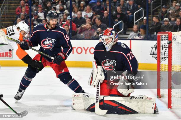 Goaltender Sergei Bobrovsky of the Columbus Blue Jackets defends the net as James Van Riemsdyk of the Philadelphia Flyers and Adam McQuaid of the...