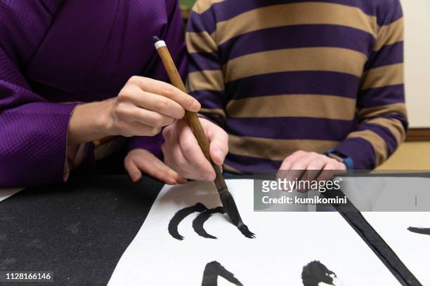 foreign people learning japanese culture - japanese calligraphy stock pictures, royalty-free photos & images