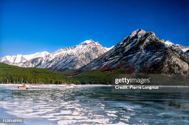 frozen lake minnewanka still, banff national park - lake minnewanka stockfoto's en -beelden