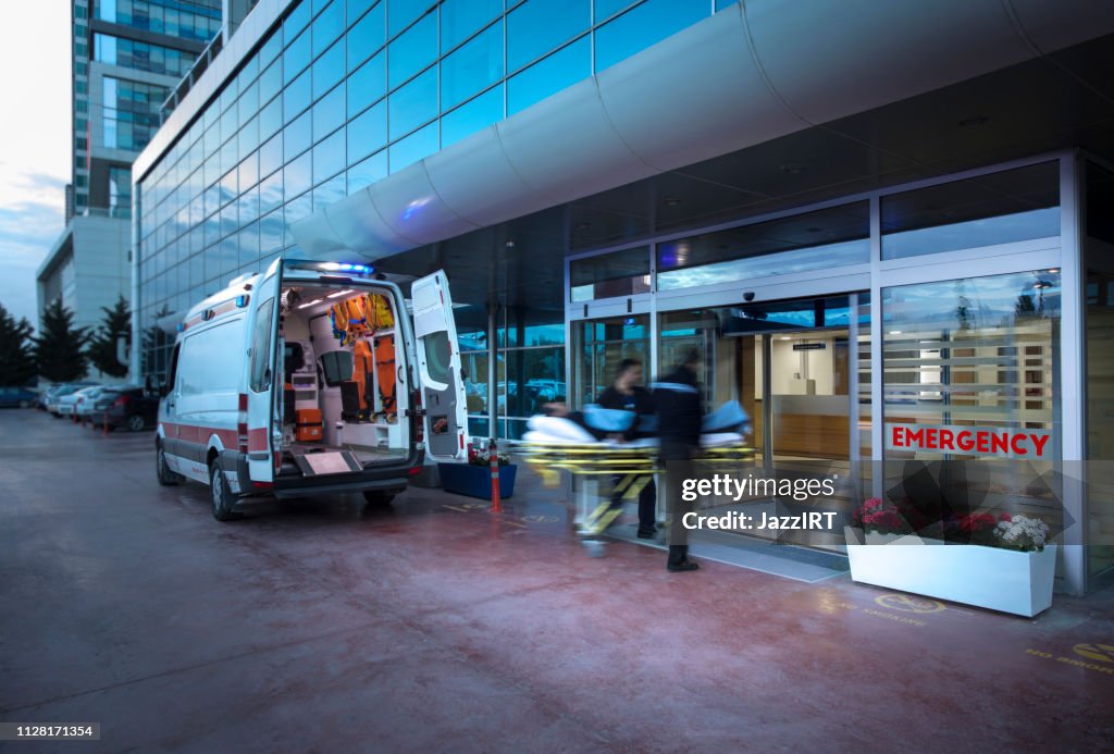 Paramedici patiënt overneemt brancard uit de ambulance naar het ziekenhuis snelheidsovertredingen ambulance, (wazig beweging)