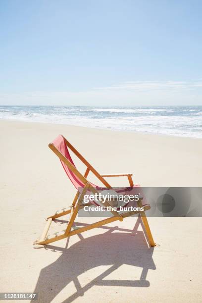 deck chair on beach against blue sky - sedia a sdraio foto e immagini stock