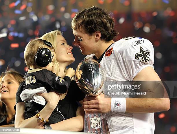 New Orleans Saints quarterback Drew Brees celebrates with his wife, Brittany, and son, Baylen, as Colts quarterback Peyton Manning leaves the field...