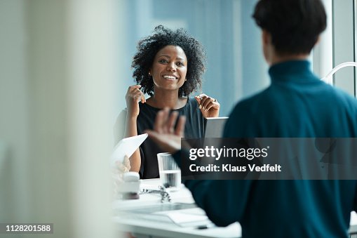 Group of co-workers standing around desk and having meeting Group of co-workers standing around desk and having meeting