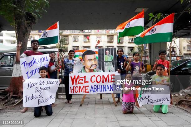 Children stand with a painting of Indian Air Force Wing Commander Abhinandan Varthaman, a day before his release from Pakistan at Lalbaug in Dadar,...