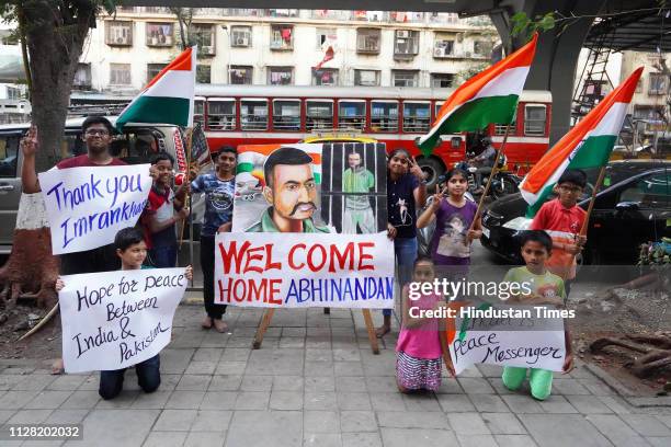 Children stand with a painting of Indian Air Force Wing Commander Abhinandan Varthaman, a day before his release from Pakistan at Lalbaug in Dadar,...
