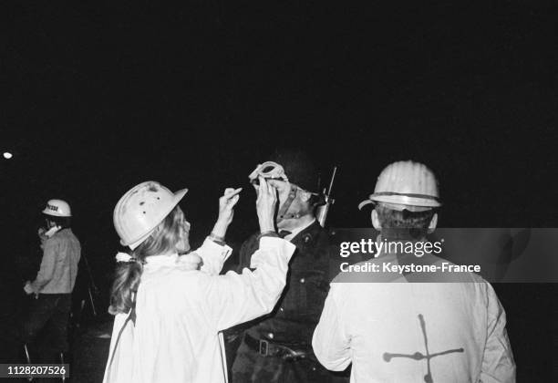 Une secouriste soigne un policier blessé à la tête, à Paris, France, en juin 1968.