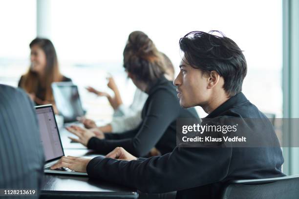 co-workers having meeting with laptop in conference room - men and women in a large group listening stock pictures, royalty-free photos & images