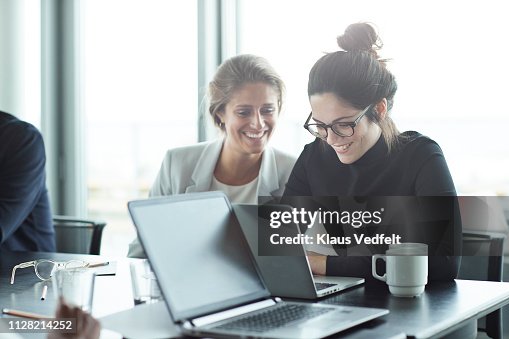 Co-workers having meeting with laptop in conference room Co-workers having meeting with laptop in conference room
