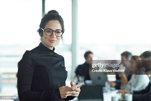 portrait of beautiful young businesswoman in meeting room - mobile device on table stock-fotos und bilder