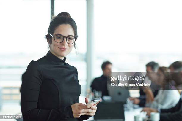 portrait of beautiful young businesswoman in meeting room - man looking at phone in public stock pictures, royalty-free photos & images