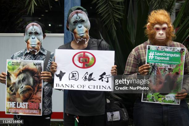 Environmental activists from Wahana Lingkungan Hidup organization wearing orangutan masks unfurled banners and posters during the International...