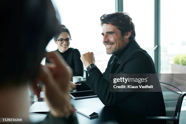 co-workers having meeting with laptop in conference room - men and women in a large group listening stock-fotos und bilder