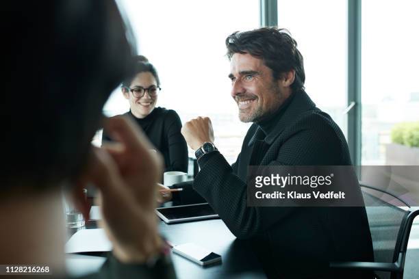co-workers having meeting with laptop in conference room - men and women in a large group listening stock pictures, royalty-free photos & images