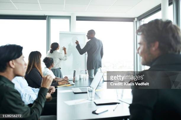 businessman doing presentation in big boardroom - men and women in a large group listening stock pictures, royalty-free photos & images