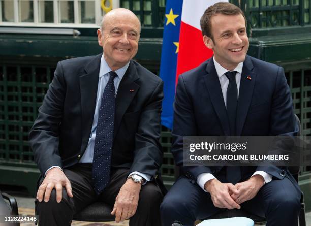 Bordeaux's mayor Alain Juppe and French President Emmanuel Macron laugh at the beginning of a meeting with local elected as part of Macron's "Great...