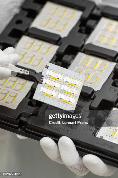 Technician holds a printed circuit board of a high-performance switching electronic at a Continental AG Powertrain production facility on March 1,...