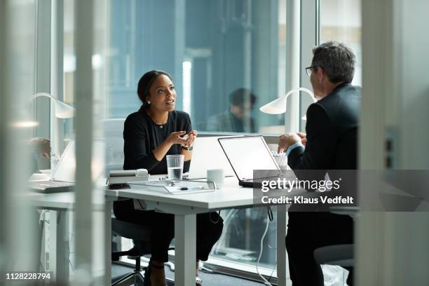 businesswoman speaking with co-worker in open office - bureaux entreprise photos et images de collection