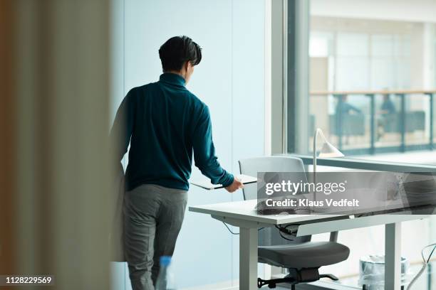 young businessman airing at desk in open office - returning bildbanksfoton och bilder