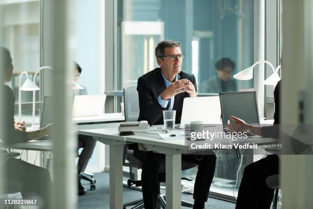 businessman speaking with co-worker in open office - finanzwirtschaft und industrie stock-fotos und bilder