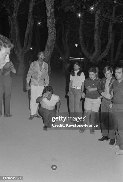 Sacha Distel jouant à la pétanque sous le regard d'Eddie Barclay à Saint-Tropez, France, le 10 août 1968.