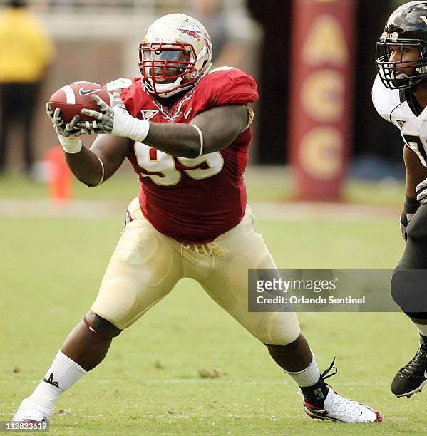 Florida State defensive tackle Jacobbi McDaniel pulls in an interception in front of Wake Forest offensive guard Joe Looney, right, at Doak Campbell...