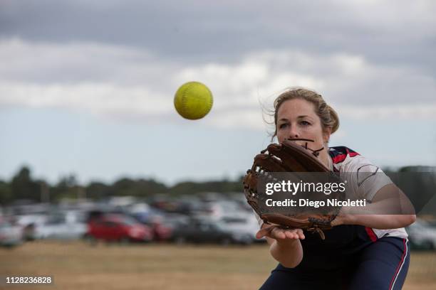 female softball player catching the ball - softball stockfoto's en -beelden