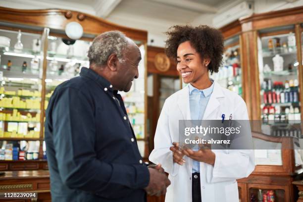 female chemist assisting senior customer - old pharmacy stock pictures, royalty-free photos & images