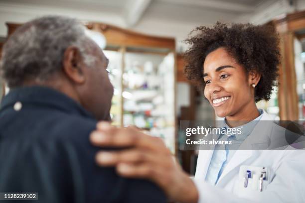 químico consoladora senior cliente en farmacia - african american man helping elderly fotografías e imágenes de stock