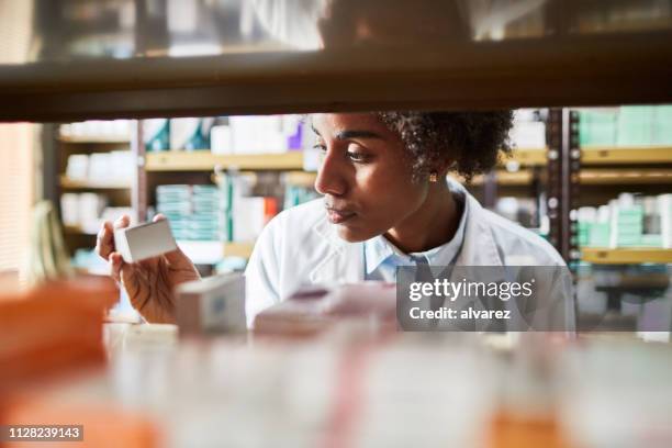 químico femenino africano que busca las medicinas - medical supplies fotografías e imágenes de stock
