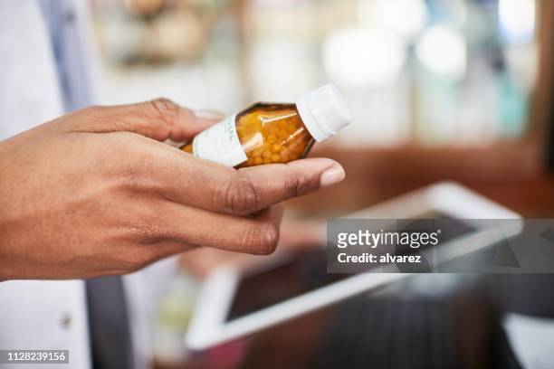 apotheker met medicijn fles en digitale tablet - homeopathie stockfoto's en -beelden