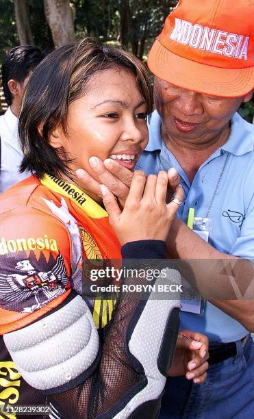 Indonesian cyclist Risa Suseanty is congratulated by Indonesian Assistant Chef de Mission Hussein Argasasmita after she won gold in the women's...