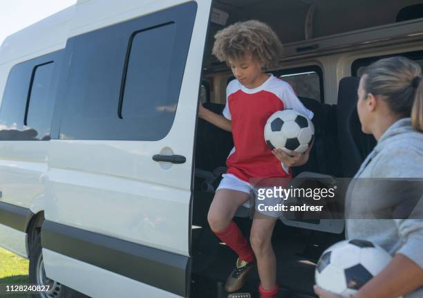 garçons heureux arrivant au camp de soccer dans un bus - coach bus photos et images de collection