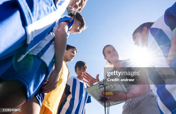 soccer mom coaching a group of kids in football practice - soccer mom stock pictures, royalty-free photos & images