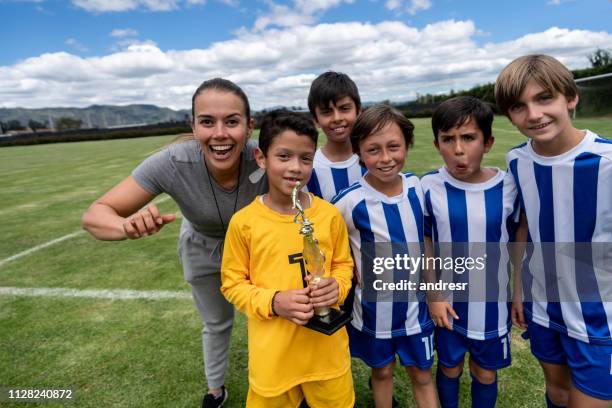 happy group of kids winning a trophy playing soccer - soccer mom stock pictures, royalty-free photos & images