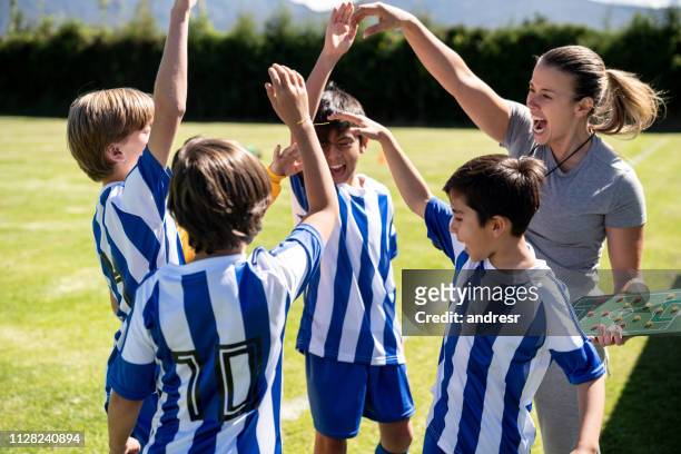 excited woman coaching a group of kids in soccer practice - parents cheering stock pictures, royalty-free photos & images