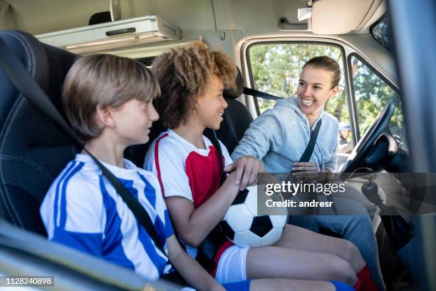 glücklich soccer mom kinder zum fußballtraining in einem lieferwagen transportieren - soccer mum stock-fotos und bilder