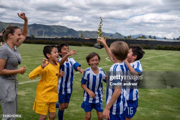 group of kids winning a trophy playing soccer - soccer mom stock pictures, royalty-free photos & images