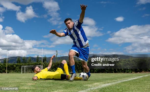 voetbalspeler die een overtreding op het veld - overtreding stockfoto's en -beelden